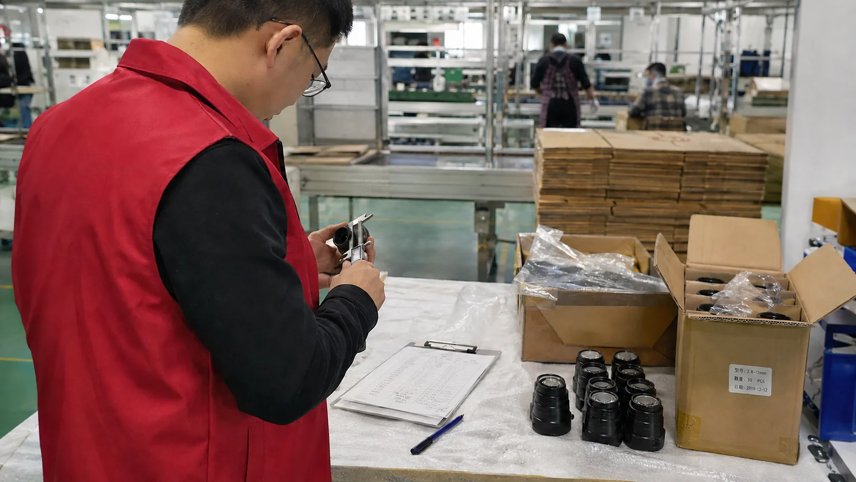 Inspector measuring product parts at a factory workbench during on-site product inspection